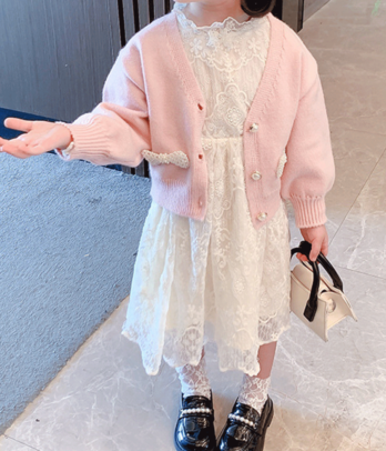 Robe blanche en dentelle et cardigan rose