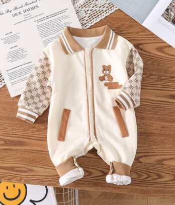 Barboteuse beige pour bébé en coton léger, dotée d’un col classique et de boutons-pression à l’avant, au style intemporel et confortable pour les premières aventures.