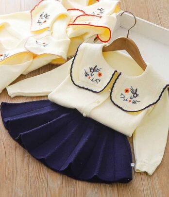 Jupe plissée bleu marine et cardigan tricoté brodé de fleurs