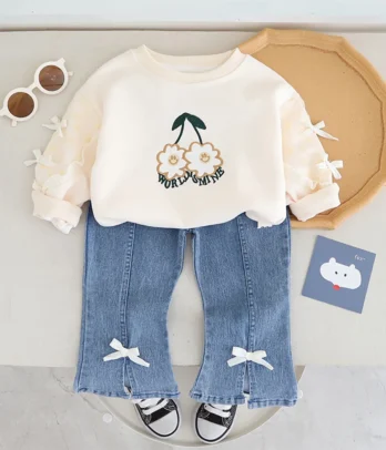 Ensemble 2 pièces fille : pull blanc brodé et pantalon en jean à pattes d’éléphant, alliant confort, style et détails raffinés pour toutes les occasions.