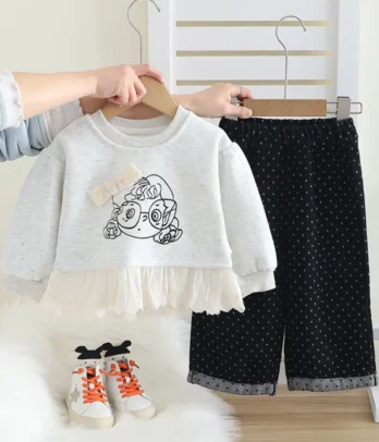 Tenue bébé fille confortable 2 pièces : sweat gris motif fille à lunettes et pantalon noir velours à pois blancs, look chic et pratique.