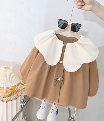 Robe beige style trench pour fille, manches bouffantes et détails élégants. Douce et fluide, elle offre un look chic et confortable pour l’automne.