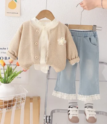 Ensemble 3 pièces : cardigan beige élégant, pull décoré d’une fleur et jean clair à taille élastique, pour un look doux, chic et confortable au quotidien.