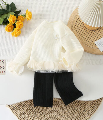 Ensemble en laine chic avec pull blanc cassé et pantalon noir. Un look minimaliste, chaud et élégant, parfait pour l’hiver et toutes les occasions.