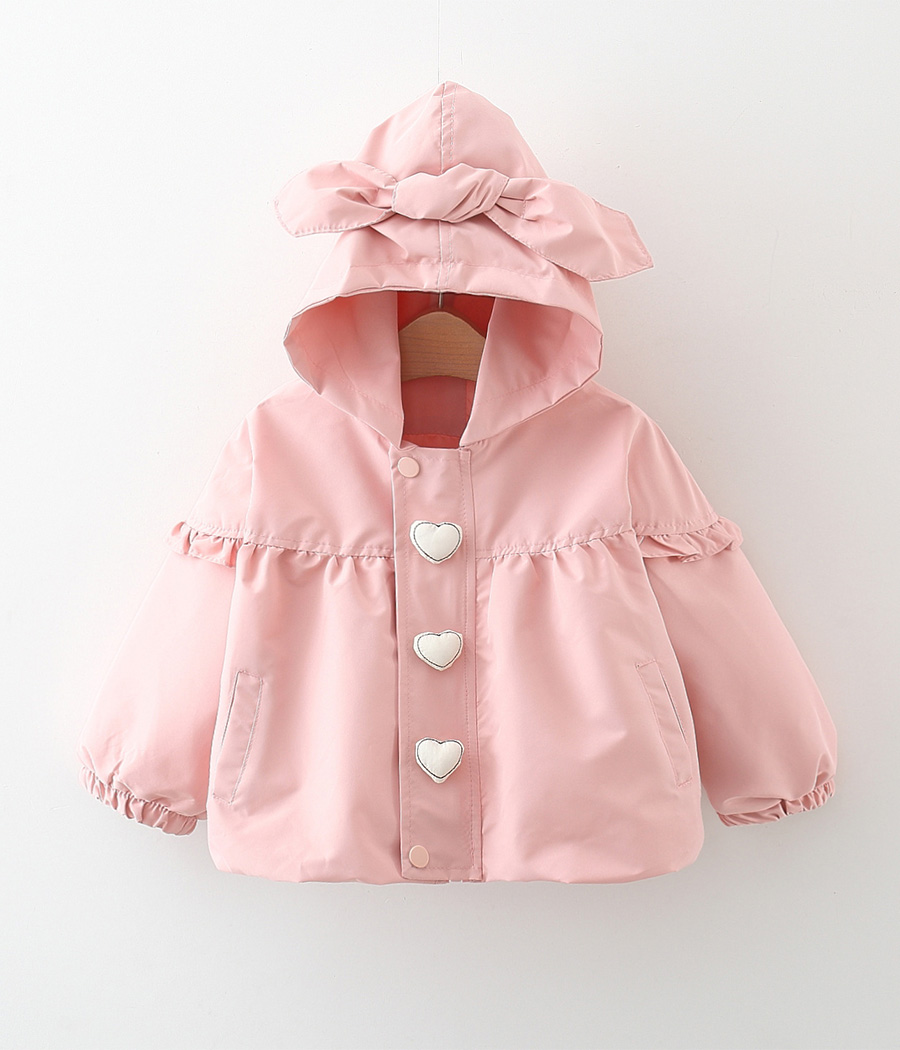 12622 (2) Coupe-vent enfant rose à capuche avec nœud décoratif, imprimé de cœurs blancs, manches longues à poignets élastiqués et double fermeture zip et boutons-pression, en tissu léger pour la mi-saison.