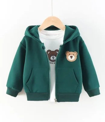 Veste bébé verte en tissu chaud et doux avec capuche intégrée, fermeture éclair et doudou décoratif cousu sur le côté, idéale pour l’automne et l’hiver.