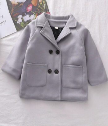 Manteau en cachemire gris bleuté pour enfant, coupe droite légèrement ajustée avec double boutonnage croisé, poches latérales et tissu doux et chaud, idéal pour l’hiver.