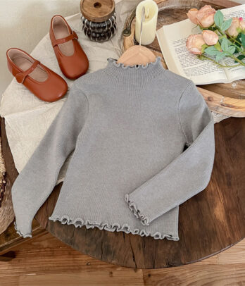 Pull tricoté gris pour enfant avec demi col roulé, maille chaude et respirante, finitions côtelées et coupe droite, parfait pour l’hiver.