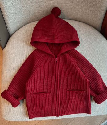 Veste rouge pour fillette avec grande capuche façon capeline inspirée du Petit Chaperon rouge, fermeture zippée, doublure douce et tissu épais. Look féérique, chic et chaud pour l’hiver.