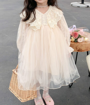 Robe princesse fille ivoire avec haut en dentelle manches longues transparentes, large col floral et jupe en tulle fluide, coupe évasée pour liberté de mouvement.