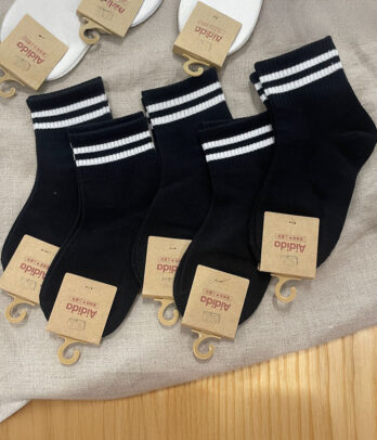 Chaussettes noires en coton avec deux bandes blanches, confortables et respirantes, idéales pour un look sport ou streetwear au quotidien.