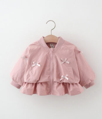 Coupe-vent enfant rose avec capuche, fermeture zippée et nœuds papillon décoratifs à l’avant, coupe fluide et légère idéale pour la mi-saison.