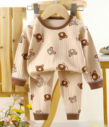 Pyjama beige avec détails marron, en coton doux et respirant. Coupe ample, pantalon à taille élastique et chevilles resserrées pour des nuits confortables.