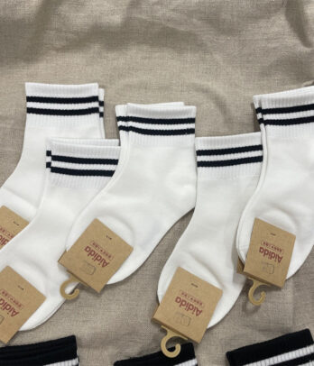 Chaussettes blanches en coton avec deux bandes noires, douces et respirantes, parfaites pour un look sport ou casual au quotidien.