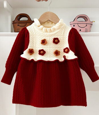 Robe enfant en laine avec haut blanc orné de fleurs en crochet et jupon rouge évasé, manches longues et col rond, coupe confortable idéale pour l’automne et l’hiver.