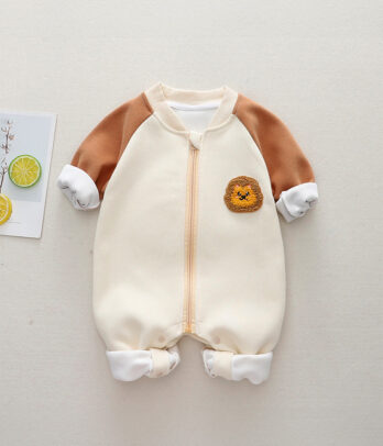 Combinaison bébé bicolore chaude avec capuche à petites oreilles de lion, détails dorés façon crinière, tissu doux et rembourré, fermeture zippée pratique. Style fun et confortable pour l’hiver.
