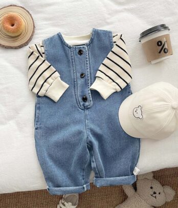 Ensemble enfant avec combinaison en jean bleu clair à bretelles ajustables et poches, assortie à un pull en maille à rayures noires à col rond et manches longues, style casual chic et confortable.