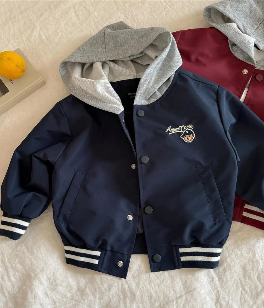 48642 Veste enfant style baseball bleu marine avec capuche gris chiné, broderie « Ourson » sur l’avant et fermeture à boutons-pression, coupe décontractée et confortable.