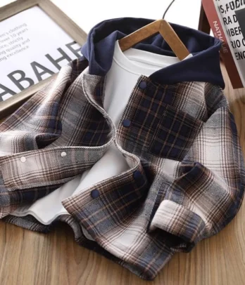 Veste streetwear à carreaux pour enfants, coupe oversize décontractée avec capuche bleu marine intégrée. Fermeture zippée ou boutonnée, doublure douce et poches pratiques, idéale pour la mi-saison.