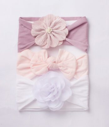 Pack "Nuage de Coton" : 3 bandeaux pastel (blanc, lila, rose clair) en tissu doux et extensible, ornés de nœuds et fleurs pour un look tendre et raffiné.