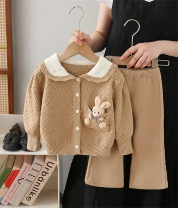 Ensemble fillette avec pull-over en maille douce à col Claudine blanc bordé de crochet et motif lapin sur la poche, assorti à un pantalon marron clair à coupe droite et taille élastiquée.