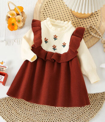 Robe pull enfant bicolore avec haut rouge brique à broderie florale sur le buste et jupe blanche en maille douce, manches longues et col rond, coupe mi-longue idéale pour l’automne et l’hiver.