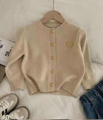 Cardigan unisexe en maille douce, style collège rétro, orné d’un blason brodé sur le devant. Coupe confortable avec fermeture boutonnée, adapté aux filles et garçons pour un look preppy chic idéal en automne ou pour la rentrée.