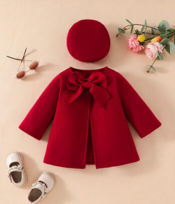 Manteau enfant rouge à manches longues avec coupe évasée et fermeture par nœud papillon, assorti à un béret rouge rappelant le Petit Chaperon Rouge.