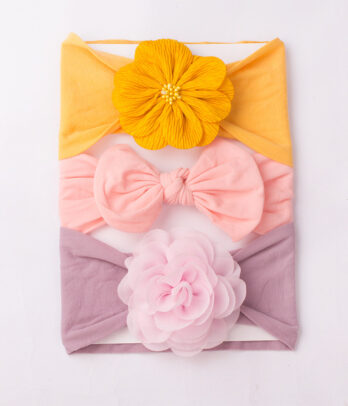 Pack de 3 bandeaux "Sakura" (rose, mauve, chamois) en coton doux et extensible, ornés de nœuds romantiques pour un look printanier plein de poésie.
