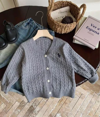 Gilet garçon style polo en maille grise avec fines torsades, col rond, coupe droite et fermeture boutonnée sur le devant, confortable pour la mi-saison.