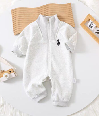 Combinaison bébé gris chiné style polo avec col boutonné, tissu doux et respirant, coupe confortable et fermeture pressionnée discrète. Élégante et pratique pour les cérémonies ou le quotidien.