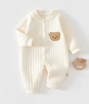 Barboteuse unisexe en coton blanc cassé, douce, pratique et élégante. Sa coupe intemporelle et sa teinte neutre en font un essentiel du quotidien de bébé.