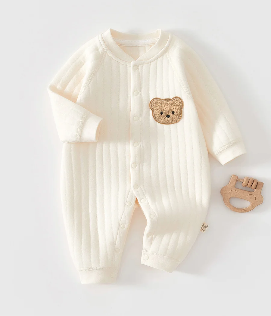 91873 Barboteuse unisexe en coton blanc cassé, douce, pratique et élégante. Sa coupe intemporelle et sa teinte neutre en font un essentiel du quotidien de bébé.