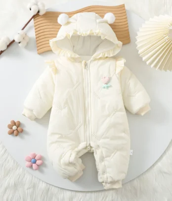Combinaison douce pour bébé fille en tissu blanc lumineux, ornée de petits nœuds ou volants, avec fermeture à pressions et zip, offrant confort, chaleur et élégance pour les premières sorties.