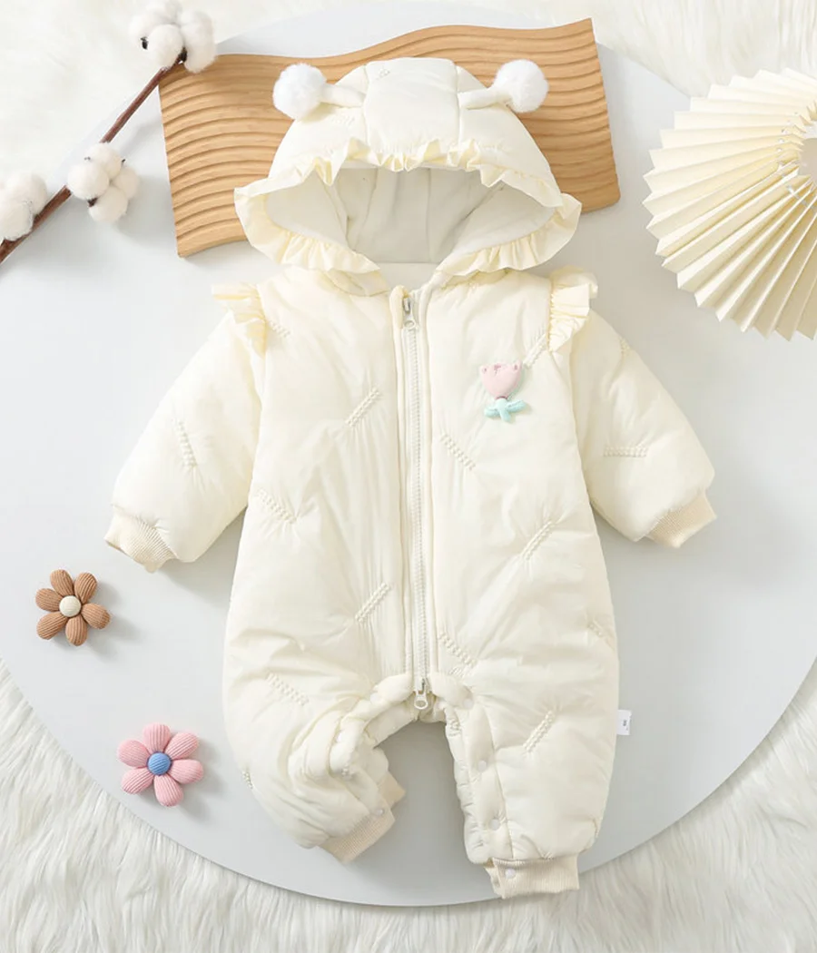 92794 Combinaison douce pour bébé fille en tissu blanc lumineux, ornée de petits nœuds ou volants, avec fermeture à pressions et zip, offrant confort, chaleur et élégance pour les premières sorties.