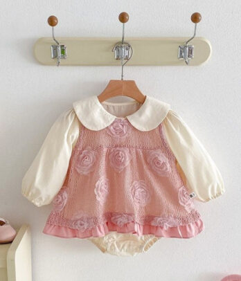 Ensemble pour bébé fille composé d’une robe rose florale évasée avec motifs en relief et finition plissée, accompagnée d’un body blanc cassé à manches longues avec col Claudine, idéal pour les cérémonies, anniversaires ou en cadeau de naissance.