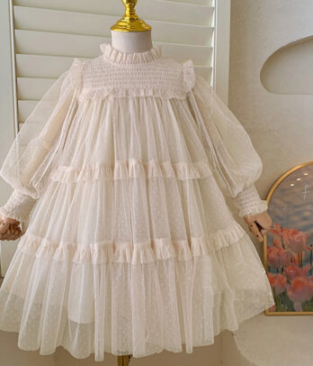 Robe princesse fille en tulle écru à volants multiples, manches longues bouffantes transparentes, col montant smocké, poignets froncés, doublure confortable.