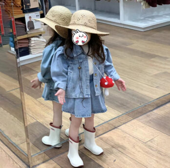Ensemble pour enfant composé d’une jupe en jean bleu brut à taille élastique et d’une veste assortie à manches bouffantes, coupe courte et col classique, idéal pour la mi-saison.