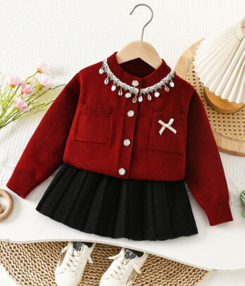 Ensemble fille 2 pièces avec cardigan rouge perlé à col orné, poches plaquées et broche nœud, jupe noire plissée à taille élastique, matière douce et chaude.
