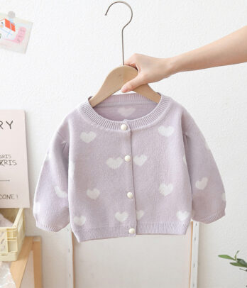 Cardigan enfant lilas à motifs cœurs blancs, fermeture à boutons nacrés, matière douce et chaude, coupe confortable, idéal pour la mi-saison et toutes occasions.