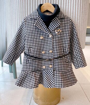 Manteau chic pour fille à motif pied-de-poule noir et blanc avec coupe évasée, double boutonnage doré, ceinture ajustable et broche cœur, idéal pour l’hiver.