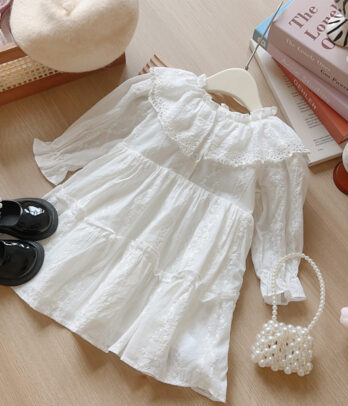 Robe blanche en broderie anglaise avec col Claudine, légère et raffinée, idéale pour les occasions spéciales ou les sorties pleines de tendresse.