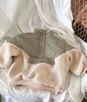 Sweat pour enfant en sherpa beige doux et chaud avec empiècement taupe, col montant à boutons-pression et coupe confortable légèrement oversize.