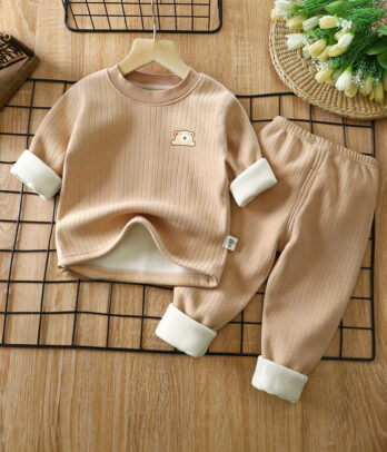 Pyjama enfant 2 pièces en coton côtelé beige, haut manches longues col rond avec broderie discrète, pantalon à taille élastique et revers, doux et chaud pour l’hiver.