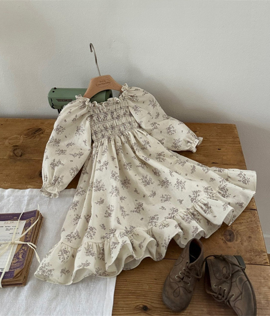 75333 Robe fillette crème à fleurs vintage avec haut smocké, manches longues bouffantes, poignets froncés et volants, tissu léger pour confort et élégance.