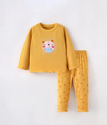 Pyjama fille jaune moutarde avec haut à col rond et pantalon à imprimé étoiles orange, en tissu doux et respirant pour des nuits confortables.