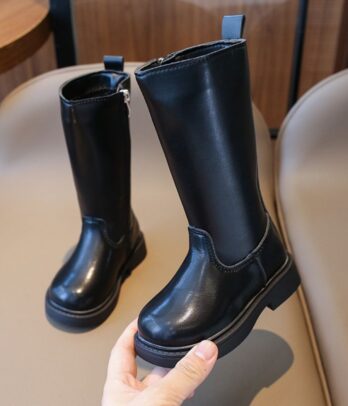 Bottes montantes noires en simili cuir avec semelle épaisse crantée. Résistantes, faciles à enfiler et parfaites pour un look urbain ou rock chic.