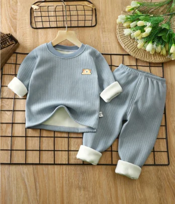 Pyjama enfant 2 pièces en coton côtelé bleu, haut col rond manches longues avec broderie discrète, pantalon à taille élastique et revers, doux et chaud pour l’hiver.